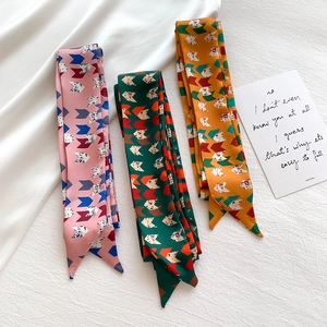 Detailed view of three colorful geometric arrow print silk scarves for hair and bags