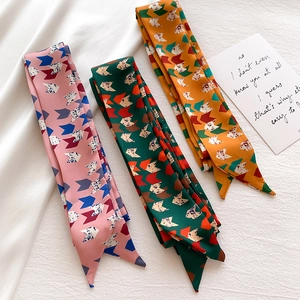 Detailed view of three printed twilly scarves featuring geometric bird patterns in three colors