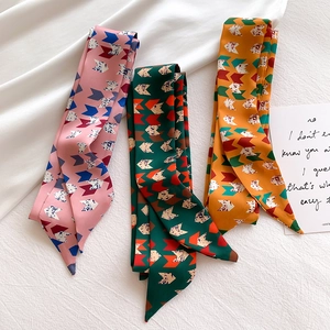 Detailed view of three colorful geometric arrow pattern silk scarves on white fabric