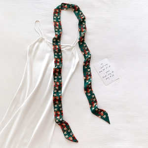 Detail of white satin dress paired with green geometric fox print silk scarf accessory