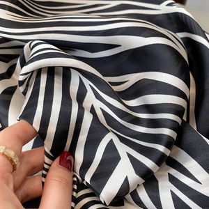 Macro shot of striped zebra pattern silk scarf showing smooth texture and soft sheen