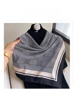 Close-up of black and white houndstooth scarf with elegant silk texture and wide black hem