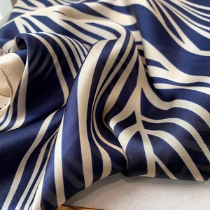 Macro shot of navy blue and off-white striped silk scarf with soft luster and rich texture
