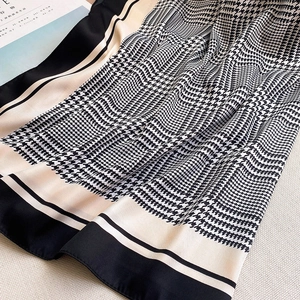 Detailed close-up of houndstooth pattern scarf with soft texture and beige border