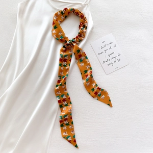 Fashionable orange silk scarf with geometric cat patterns displayed on a white dress