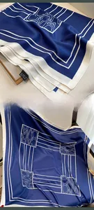 Dettaglio foulard in seta blu navy e bianco con etichetta di lavaggio e logo elegante
