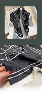 Dettaglio di un foulard quadrato in finta seta con motivi geometrici classici in bianco e nero