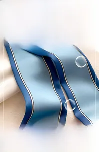 Gros plan sur l'écharpe en soie à rayures bleues montrant la couture et la texture lisse