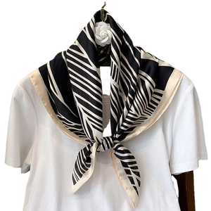 Classic black and white geometric striped square silk scarf tied as a stylish necktie