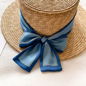 Gros plan d'un chapeau de paille canotier orné d'un ruban en satin bleu marine chic
