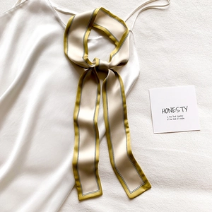 Gros plan d'une écharpe en satin élégante nouée sur une robe blanche comme ceinture