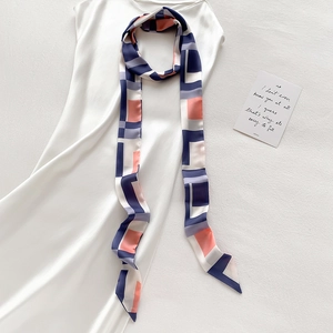 Élégant foulard long en soie à motif géométrique sur une robe en satin blanc