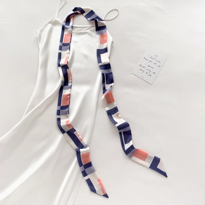 Détail d'un foulard en soie aux blocs de couleurs sur une robe en satin