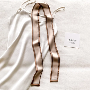 Mise à plat d'un caraco en soie blanche et d'un foulard twilly étroit rayé beige