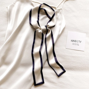 Élégant foulard étroit en satin blanc avec bordure noire assorti à une robe en soie