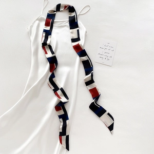 Détail d'un foulard en soie géométrique assorti à une robe en satin à bretelles