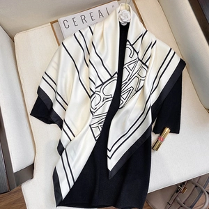 Foulard quadrato in seta blu e bianco con lettere geometriche su sedia beige