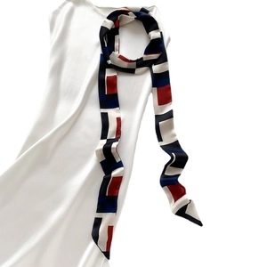 Élégant foulard en soie à imprimé géométrique avec motifs carrés sur une robe blanche