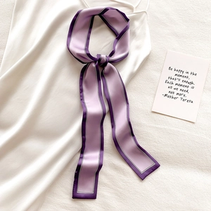 Élégant foulard en soie violette avec rayures foncées sur une robe en satin blanc