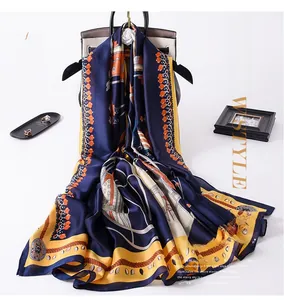 Detail of vintage carriage chain print scarf with silk-like texture draped over a bag
