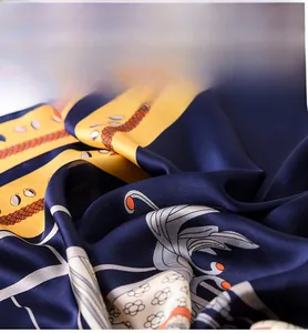 Detail of silk-like scarf showing luxury chain pattern and smooth fabric texture