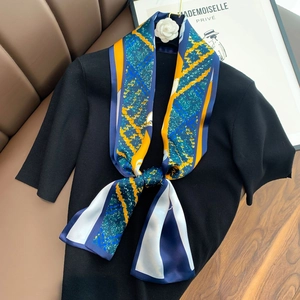 Detailed view of an elegant silk twilly scarf with blue and orange abstract patterns