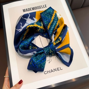 Detail of silk scarf with equestrian horse print in navy blue and yellow colors