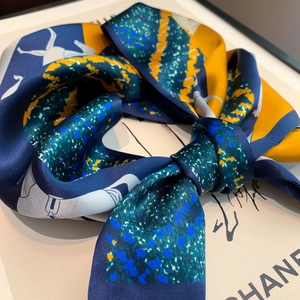 Detail of silk scarf featuring abstract figure prints and smooth satin texture
