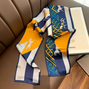 Close-up of a long silk scarf with horse patterns on a premium leather sofa