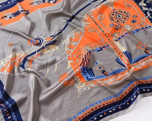 Macro shot of silk scarf showing vintage horse carriage pattern and smooth texture