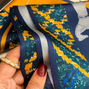 Close-up of luxury silk scarf with equestrian horse harness prints and satin texture