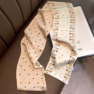 Detail of elegant champagne silk scarf with black polka dots and rabbit pattern