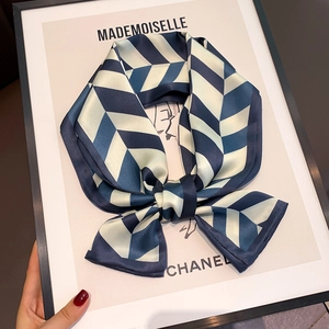 Detail of elegant silk scarf with blue and cream chevron pattern and rolled edges