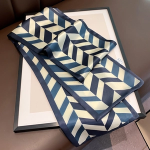 Close-up of geometric V-pattern silk scarf with satin finish and quality tag