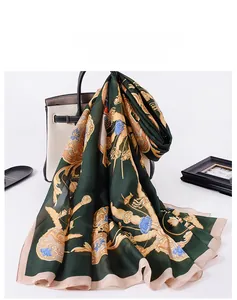 Detail of silk scarf with vintage chain and floral print draped over a handbag