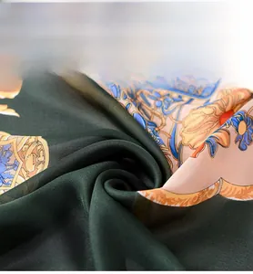 Close-up of silk-like dark green fabric with baroque floral patterns and smooth folds