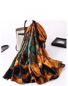 Close-up of premium vintage floral silk scarf draped over a white luxury handbag