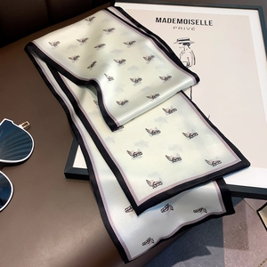 Detail of mint green silk scarf with horse print and black borders on leather