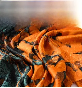 Close-up of soft orange silk fabric with blue mottled pattern and pearly luster texture