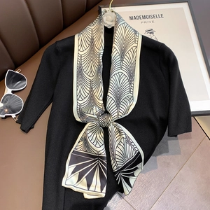 Detail of silk skinny scarf with geometric patterns on black knitwear top