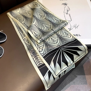 Close-up of long silk scarf with Art Deco geometric fan pattern and satin finish