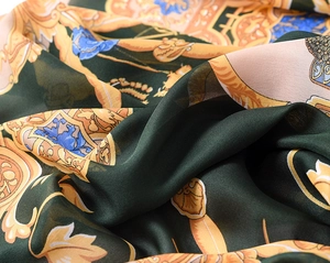 Detailed view of luxurious baroque print silk scarf with emerald green and gold patterns