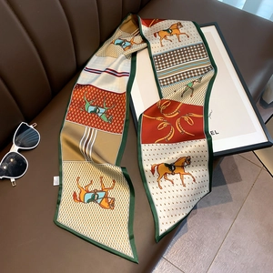 Detailed view of luxury silk scarf with horse print on elegant leather sofa background