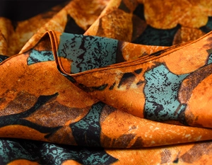 Detailed macro view showing the satin sheen and fine stitching on the floral silk scarf