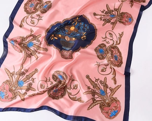 Detailed view of pink silk scarf with navy trim and vintage floral fruit pattern