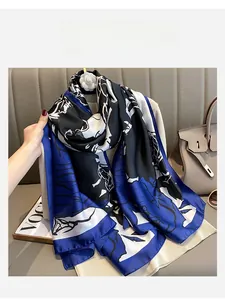 Artistic blue and black printed silk scarf styled over clothing with abstract patterns