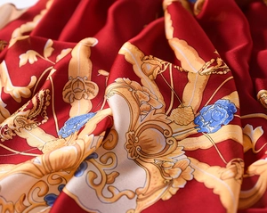 Detailed macro view of red silk scarf fabric with golden baroque patterns and floral print