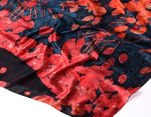 Detail of red leaf pattern on silk scarf with premium fabric texture and drape