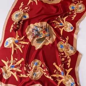 Detail of baroque pattern on luxury crimson silk scarf with gold scrollwork and floral accents