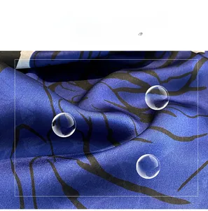 Detailed close-up of smooth navy blue and black branch-patterned faux silk scarf fabric